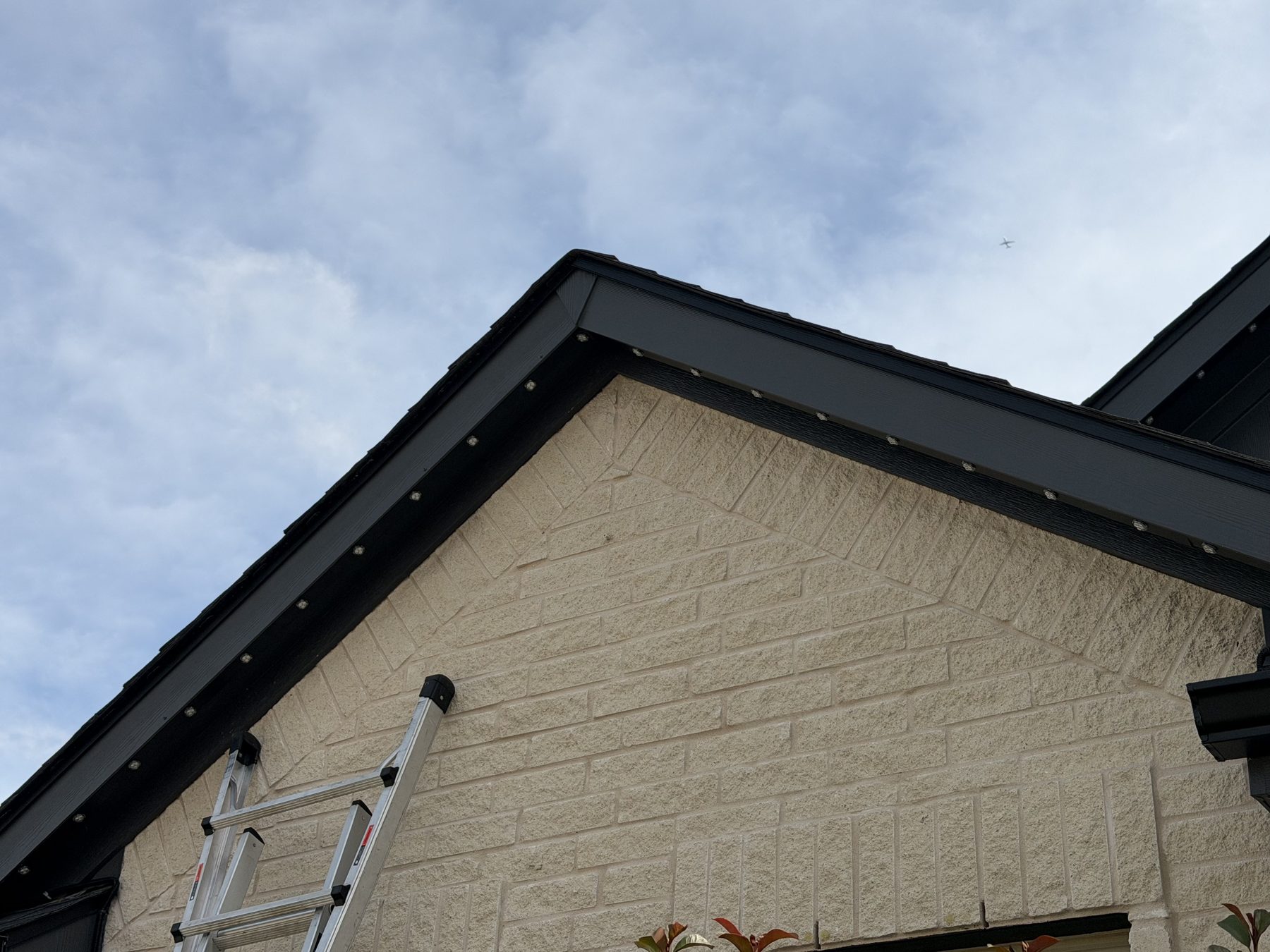 Daytime view of permanent lighting track mounted flush with black fascia, nearly invisible