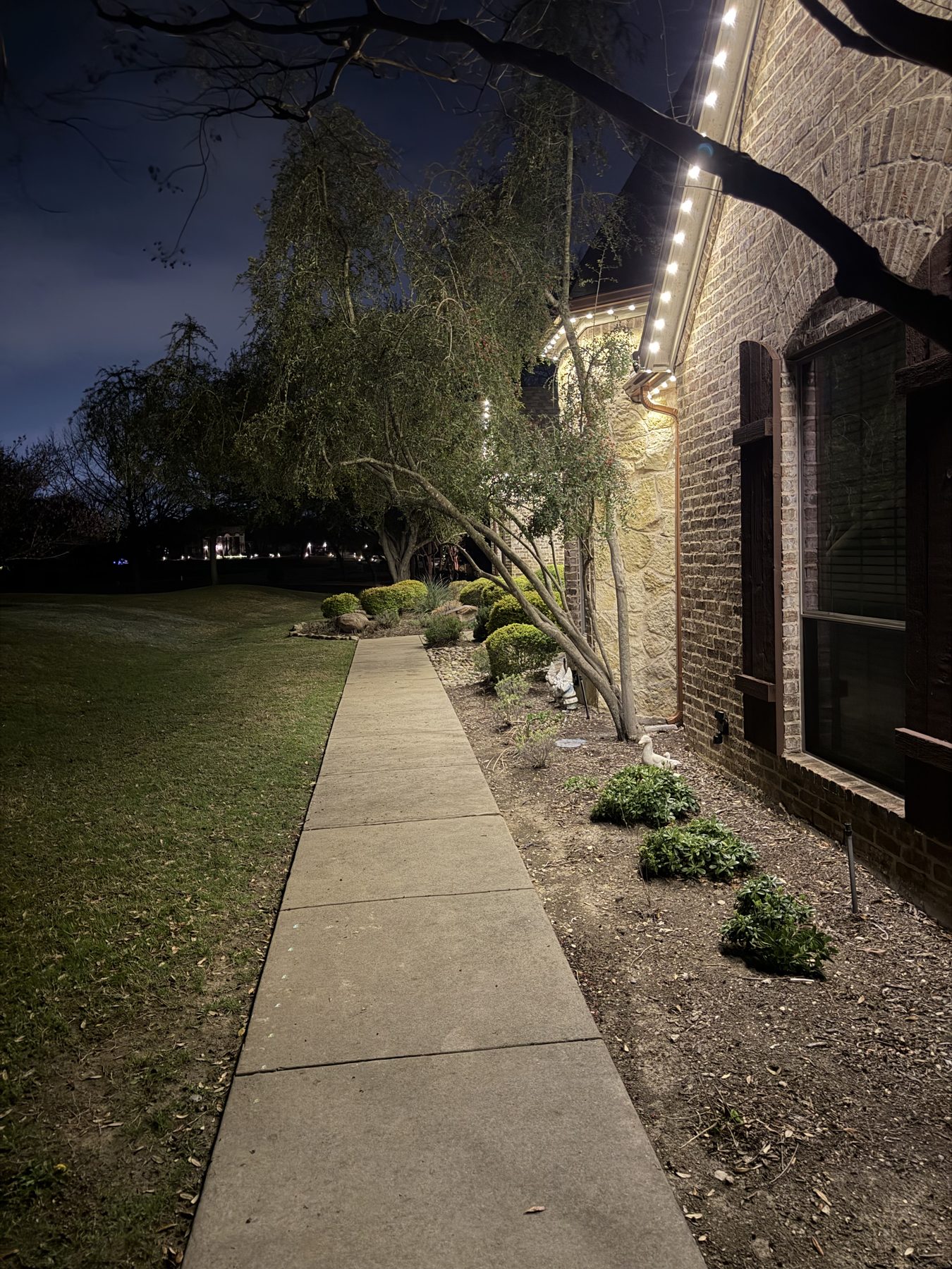 Permanent lights washing bright, even light down a home's walls and sidewalk at night