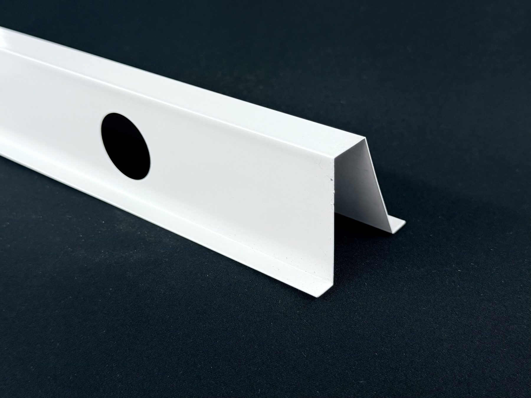 White crown-style aluminum track profile for soffit-mounted permanent lighting
