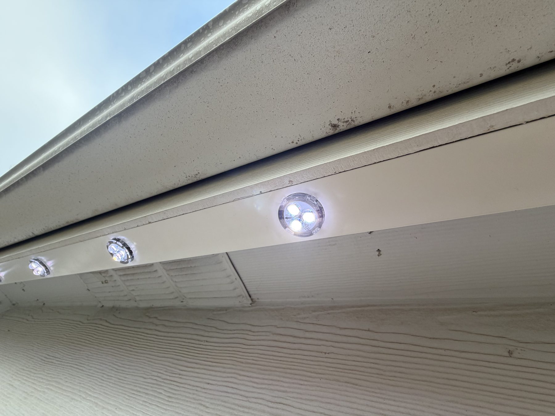 Track-mounted lighting system installed flush with the fascia, color-matched to the trim