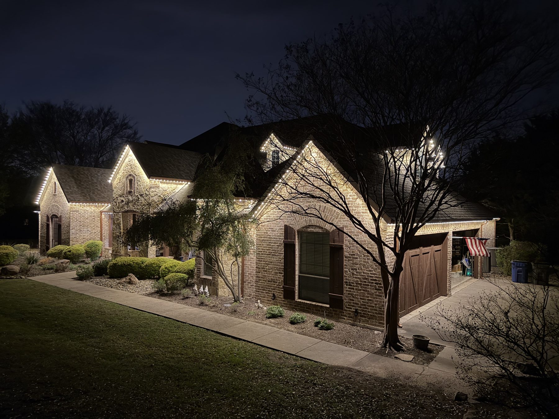 Brick home and garage in soft warm white permanent lighting